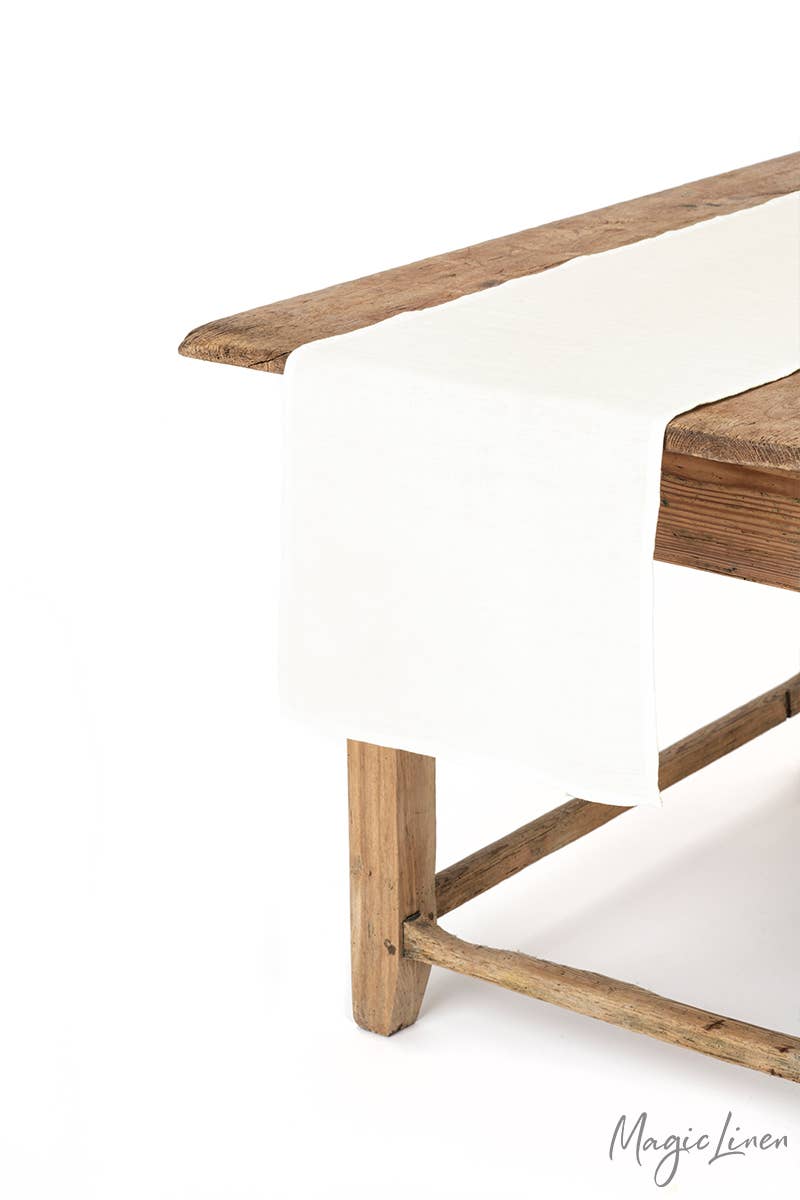 MagicLinen - Linen table runner on a wooden table, showcasing its soft texture and decorative appeal. Ideal for enhancing kitchen settings.