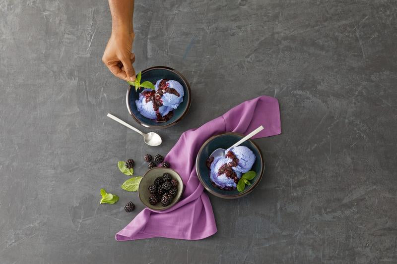 Zwiesel Fortessa | Arezzo Flatware Serving Set, Brushed, with silver spoons beside bowls of berry ice cream on a slate surface, showcasing elegance and precision.