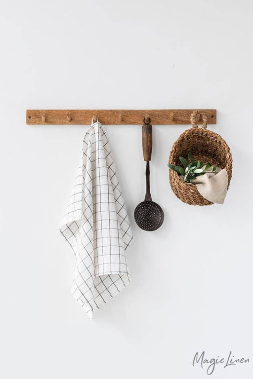 Linen tea towel with hanging loop on a hook, showcasing its absorbency and durability, ideal for kitchen use. Perfect for maintaining a tidy cooking space.