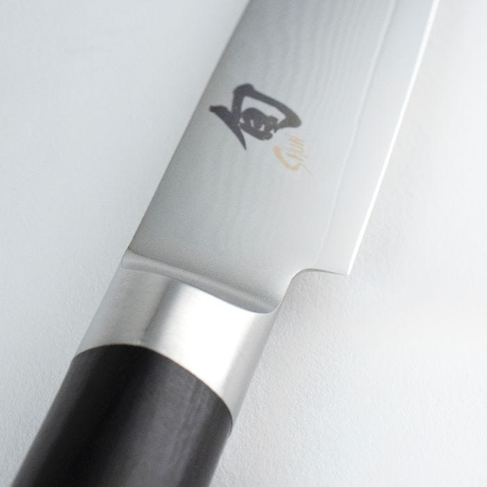 Shun Classic Paring Ebony, 3.5 inches knife showing its kanji-stamped blade transitioning into a D-shaped ebony-finished handle, highlighting craftsmanship and versatility.