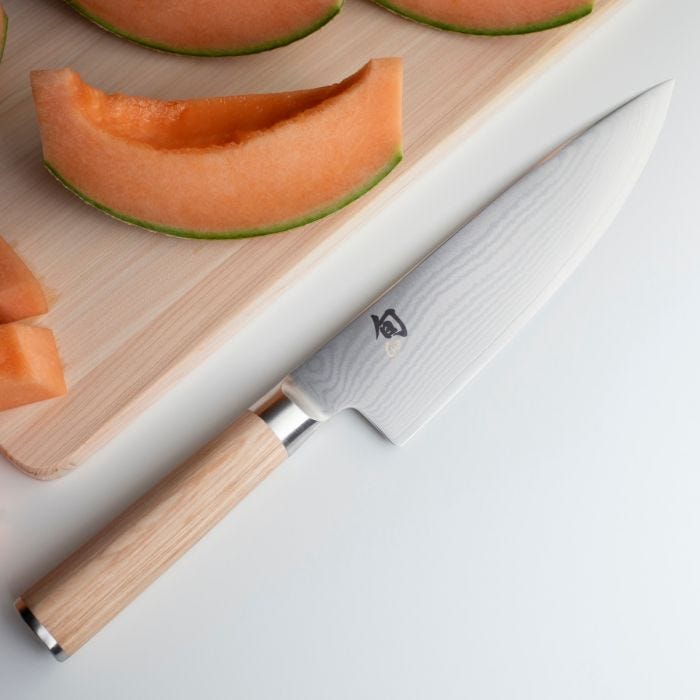 Shun Classic Chef's Blonde 8-in. Knife on board with cantaloupe slices, showcasing its precision and versatility for preparing fruits and more.