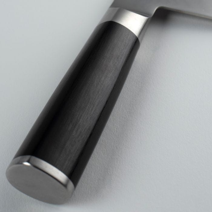 Shun Classic Vegetable Cleaver, 7 inches, features a close-up of its D-shaped Pakkawood handle with a metal bolster and end cap, ideal for versatile kitchen tasks.