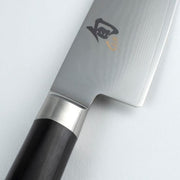 Close-up of the Shun Classic Santoku Ebony, 5.5 inches, showcasing its straight-edged Damascus blade and wooden handle, ideal for versatile kitchen tasks.