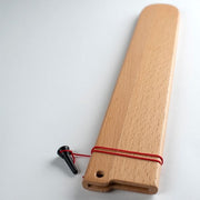 Shun Classic Hollow Ground Brisket Knife with wooden saya sheath featuring a flat board with hanging hole and adjustable red cord for secure blade protection.