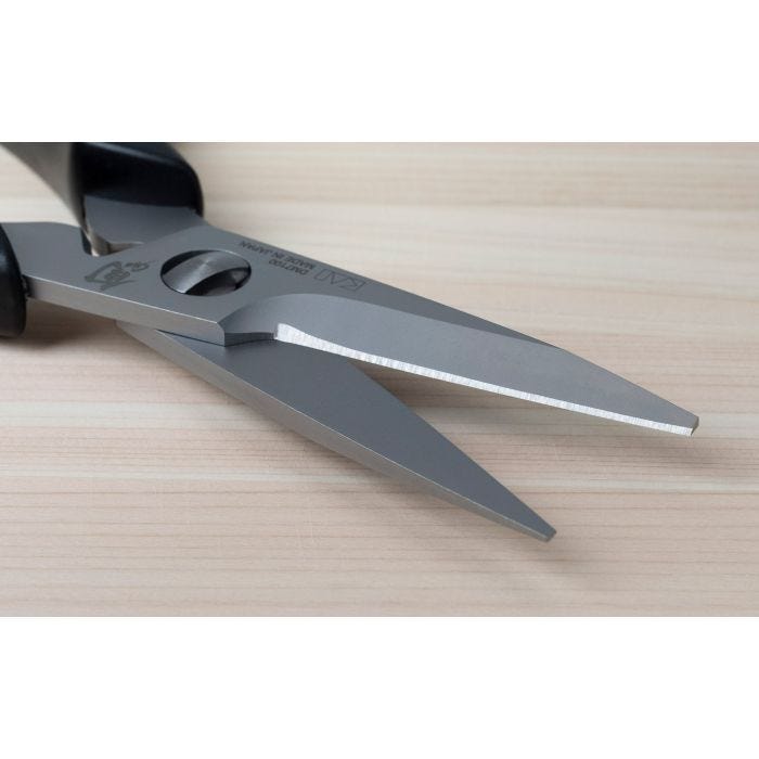 Shun Kitchen Herb Shears, 7.5 inches, with stainless-steel blades and black handles, designed for precise herb cutting, resting on a light wood surface.