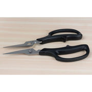 Shun Kitchen Herb Shears, 7.5 inches, with black handles and pointed metal blades, designed for precision cutting, laid on a wood-grain surface.