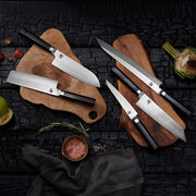 Shun Dual Core Nakiri knife displayed with artichoke, tomatoes, salt, and rosemary on rustic cutting boards, showcasing its high-end design and culinary versatility.