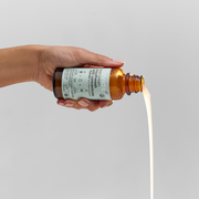 Hand pouring Davids Hydroxi™ fresh breath mouthwash refill concentrate, showcasing sustainable glass bottle design and enamel health focus, aligning with Athens Cooks' curated kitchen essentials.