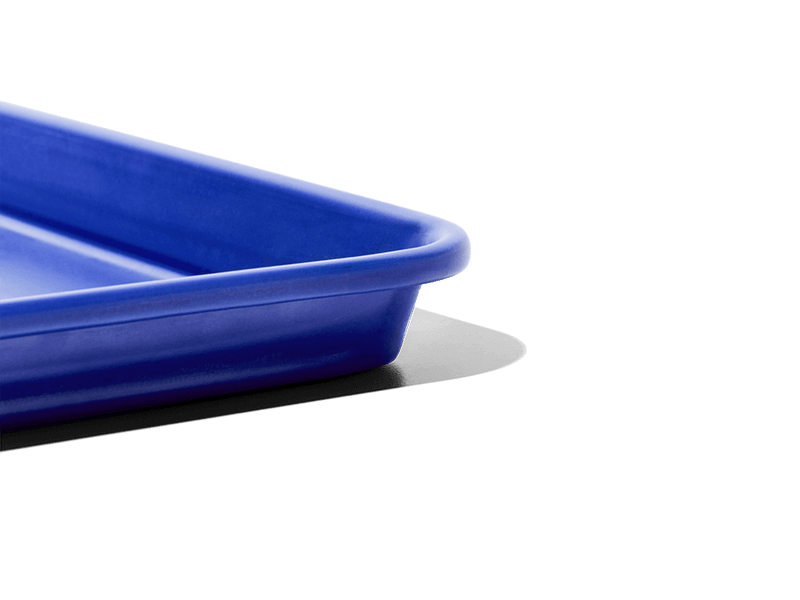Great Jones | Little Sheet - Pepper, a small, nonstick sheet pan ideal for baking and reheating, showcased against a black backdrop, embodying Athens Cooks' curated kitchen essentials.