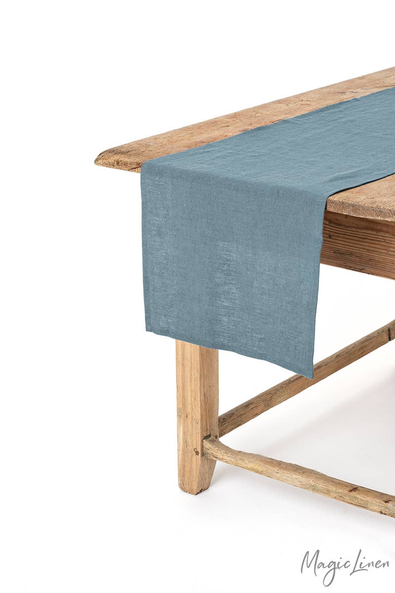MagicLinen - Linen table runner elegantly draped on a wooden table, showcasing its soft texture and decorative appeal, ideal for enhancing kitchen or dining settings.