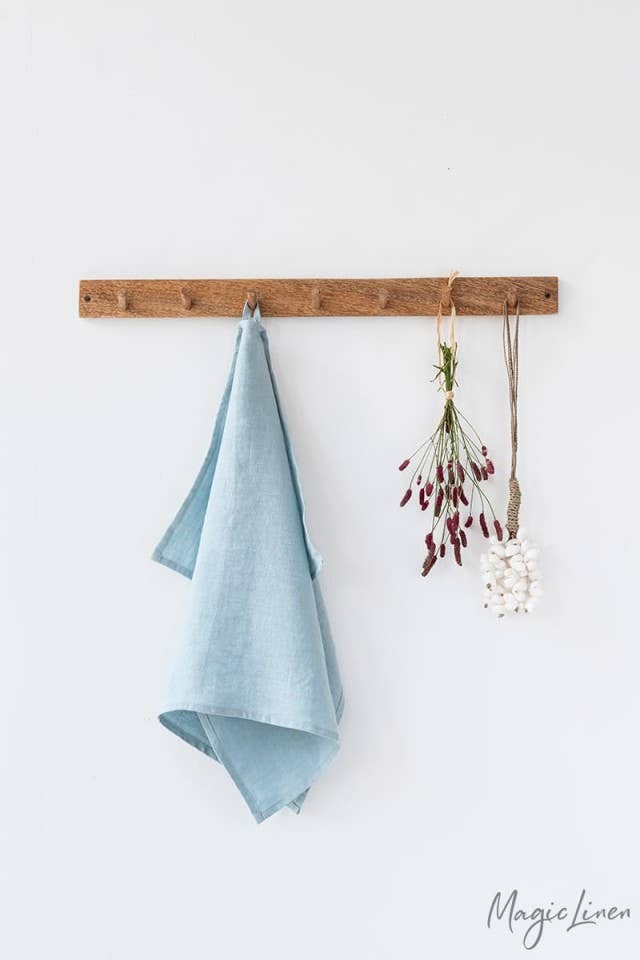 Linen tea towel with a hanging loop, displayed with flowers, showcasing its high-quality European fabric and absorbent durability. Perfect for kitchen use.