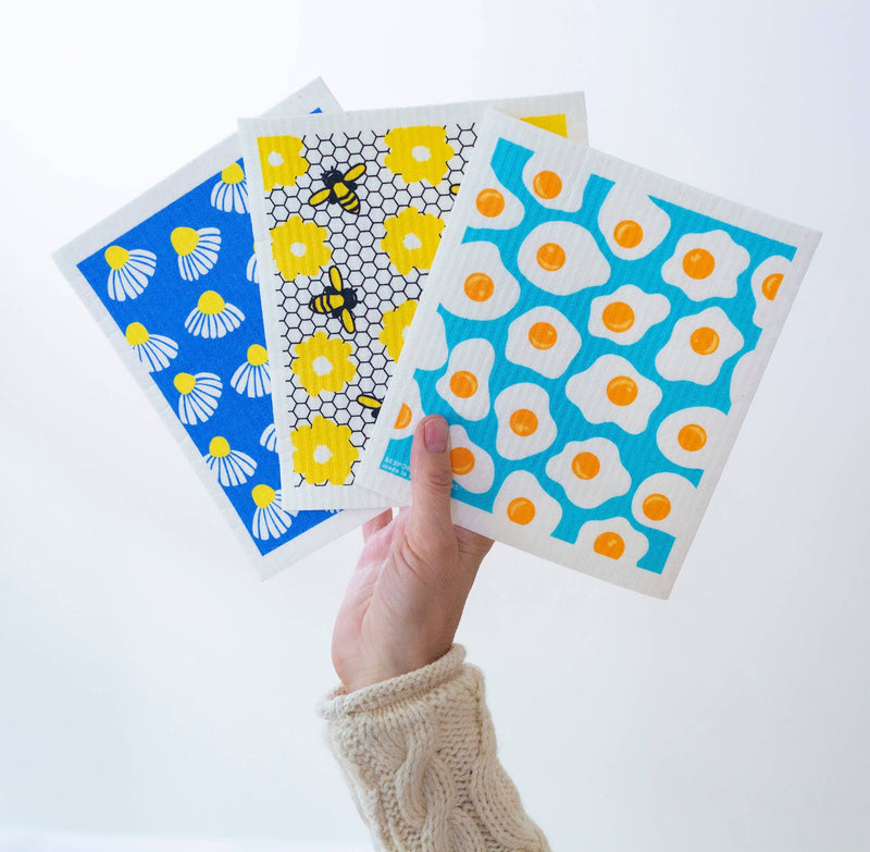Bespoke Provisions - Eggs Swedish Dishcloth shown being held, highlighting its paper towel alternative use. Made from cotton and cellulose, ideal for cleaning various surfaces.