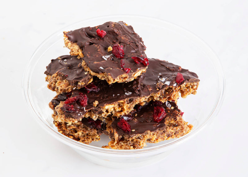 KnekkeGodis Valentine's Special: A bowl of chocolate-covered crispbread with cranberry drizzle, showcasing a Nordic sweet treat from Norwegian Baked.