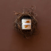 Among the Flowers - Essential oil candle | HOLIDAY: Hearth nestled in a bird-nest bowl, featuring ivory soy wax with amber decor.