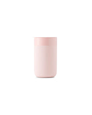 Reusable ceramic mug with pink lid, 16 oz, features a splash-resistant lid and silicone sleeve for grip. Ideal for sustainable coffee drinking.