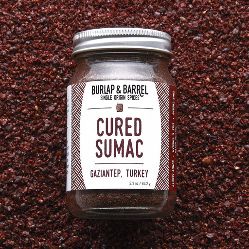Burlap & Barrel - Cured Sumac, 2.3 oz jar, on coarse granules; a Middle Eastern spice with bright, sour flavors, ideal for enhancing various dishes.