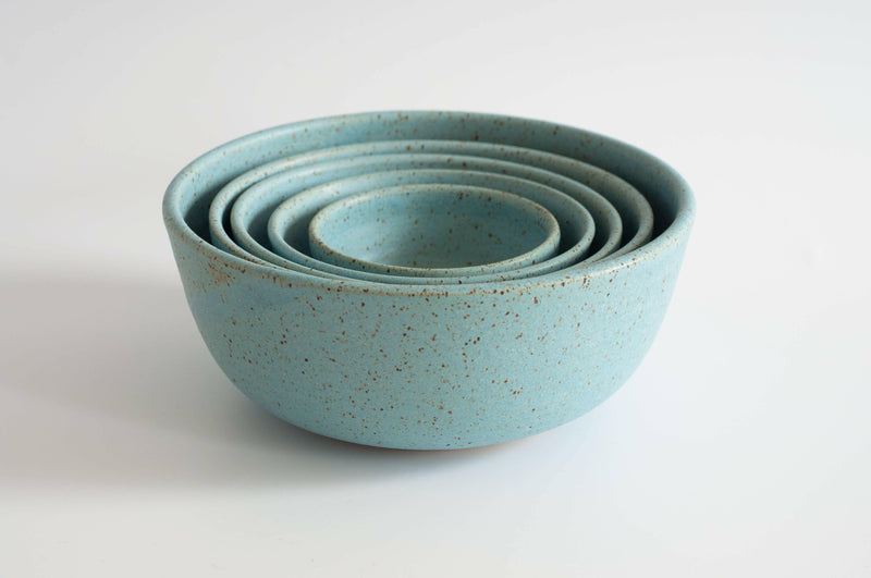 RachaelPots | Set of Three Nesting Bowls - Robin's Egg Blue, showcases hand-thrown, speckled turquoise ceramic bowls, skillfully nested, ideal for versatile kitchen use.