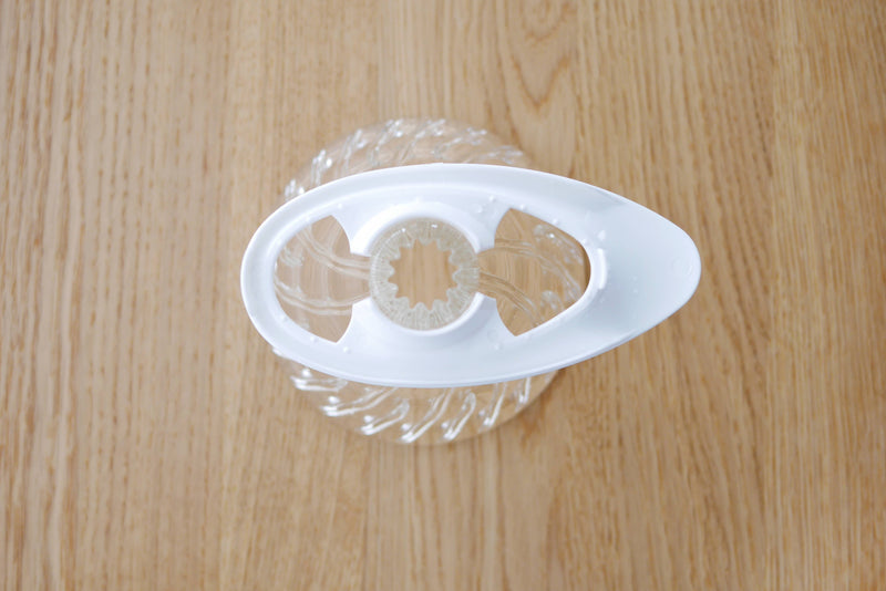 Disassembled HARIO V60 Glass Dripper 02 with Olive Wood holder, featuring a clear glass collector and white plastic reamer, ideal for enhancing coffee brewing at Athens Cooks.