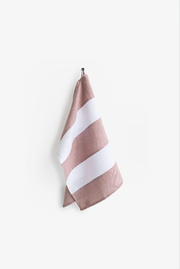 Striped linen tea towel hanging on a hook, showcasing its practical loop for easy storage. Part of MagicLinen's zero-waste collection, ideal for eco-friendly kitchens.