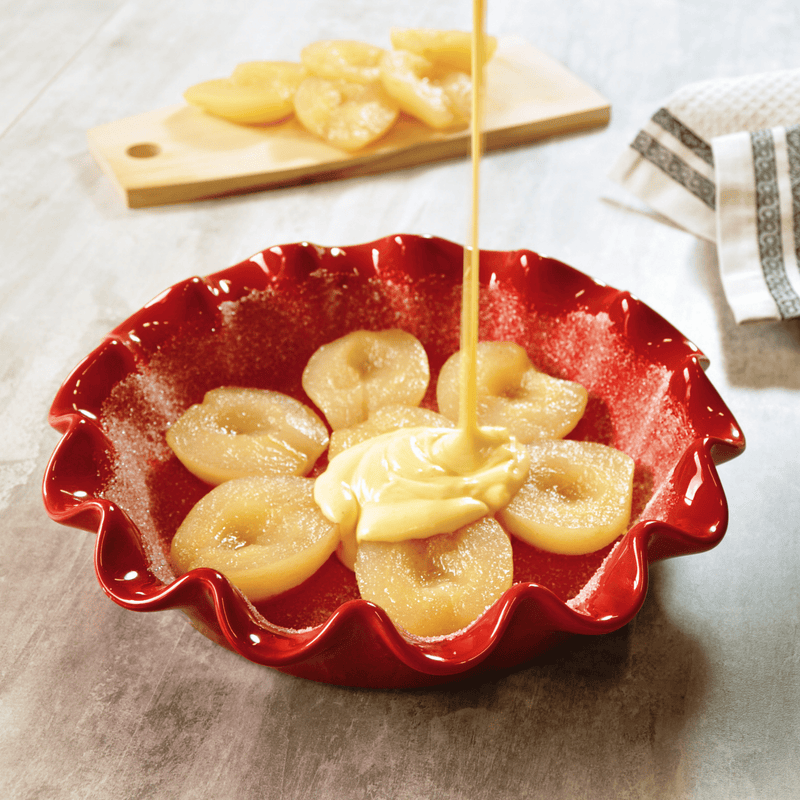 Emile Henry | Deep Ruffled Pie Dish with pears and batter, showcasing its even heat distribution and elegant ruffled design for perfect baking results.