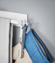 Yamazaki Home - Magnetic Kitchen Towel Hanger - Steel: White, featuring hooks with textiles and a clip, ideal for organizing kitchen towels and accessories.