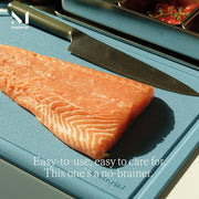 Material - The MK Free Board: Ocean displayed with a salmon fillet and chef’s knife, promoting its plant-based, non-porous, microplastic-free surface, ideal for safe food preparation.