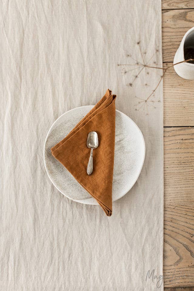 Set of 2 linen napkins on a plate with a spoon and napkin, showcasing MagicLinen's quality table decor perfect for any kitchen setting.
