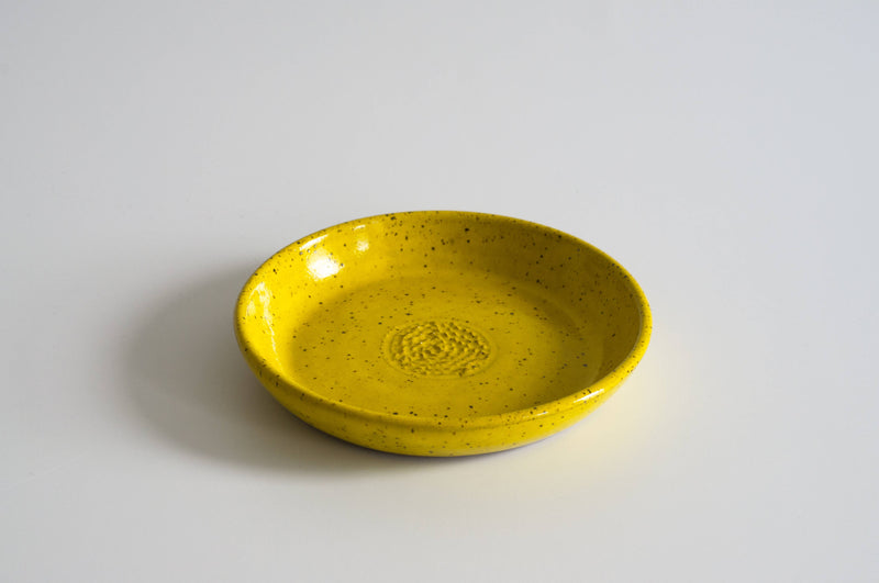 RachaelPots - Garlic Scraper: Yellow, a hand-thrown ceramic dish with speckles, perfect for pureeing garlic. Microwave and dishwasher safe, crafted in Brooklyn.