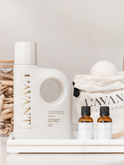 L'AVANT Collective Wool Dryer Balls pack of 3, styled with fragrance oil and clothespins, offering an eco-friendly laundry solution on a marble tray.