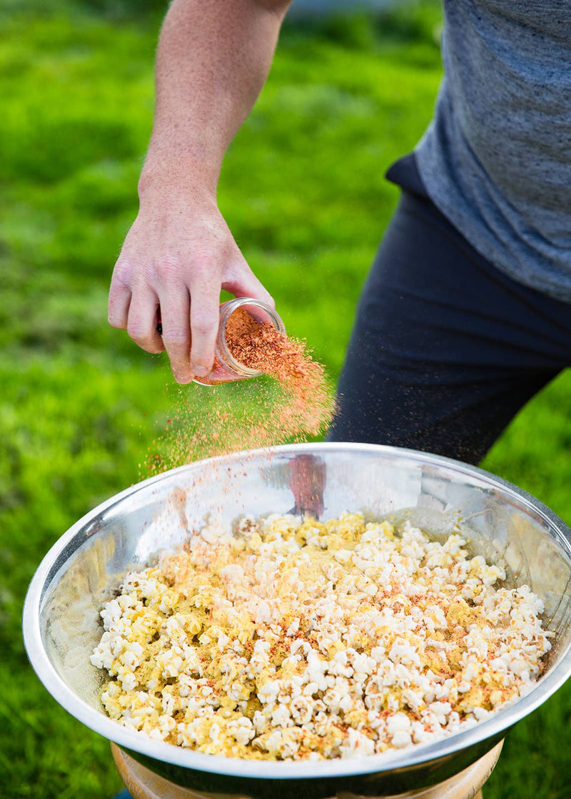San Juan Island Sea Salt - Kimchi Seasoning Blend sprinkled over popcorn outdoors, showcasing its tangy spice blend with Gochugaru peppers, ginger, and garlic.