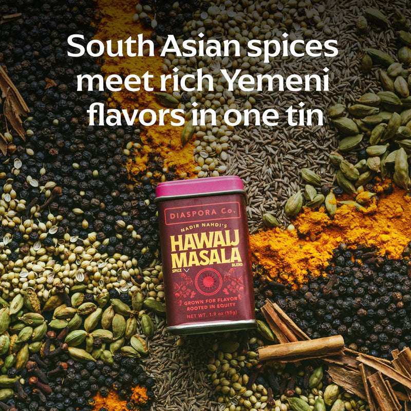 Diaspora Co. - Hawaij Masala Spice Blend tin surrounded by black peppercorns, cardamom, cumin, coriander, turmeric, cloves, and cinnamon, highlighting South Asian and Yemeni flavors.