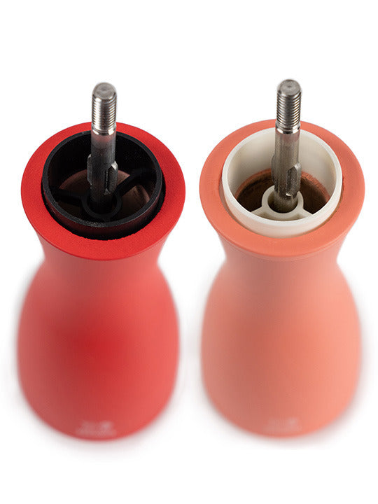 Peugeot | Tahiti Duo Salt + Pepper Mills, Fire, showcasing exposed grinding mechanisms, with one mill in deep red and the other in soft peach, ideal for culinary elegance.