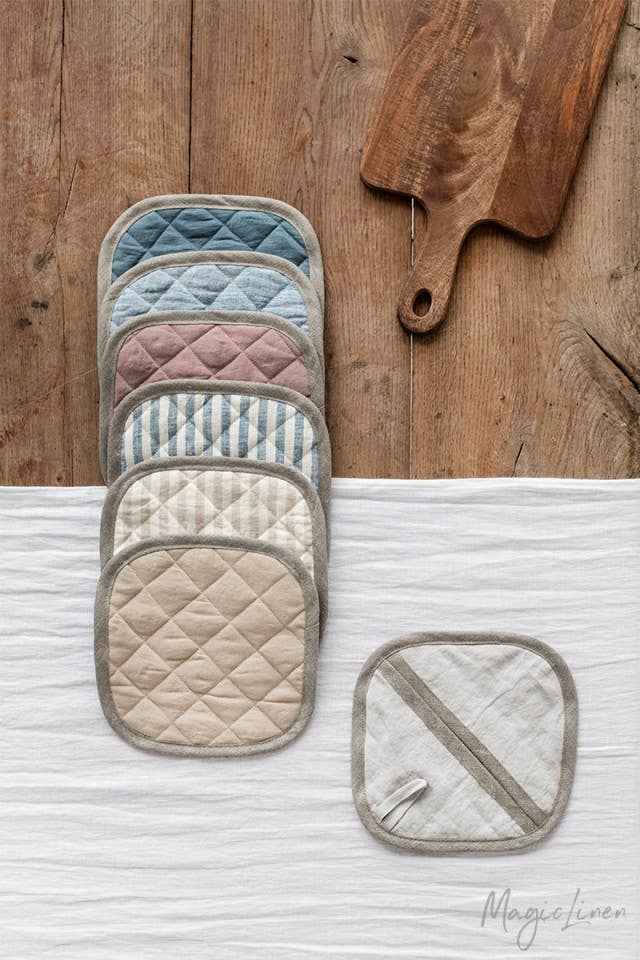 MagicLinen linen pot-holder, quilted with heat-insulating padding, displayed with matching kitchen mitts on a wooden surface, perfect for stylish, practical kitchen use.