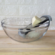 Microplane | Bowl Graters, Fine resting on a glass bowl, grating Parmesan cheese. Ideal for efficient, safe kitchen prep at Athens Cooks.