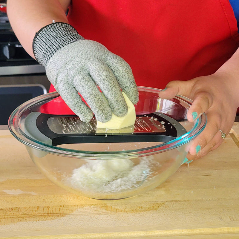 Person grating cheese with Microplane | Bowl Graters, Fine, over a mixing bowl, highlighting its efficient, mess-free design for hard cheeses and more.