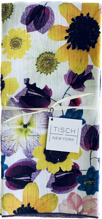 Tisch New York Floral Tea Towel close-up, featuring intricate flower patterns and a care tag, sold individually, 17x25, pre-washed, made in USA, suitable for kitchen use.