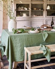 MagicLinen forest green linen tablecloth, 59 x 98 inches, with simple seam finish, perfect for dining settings.