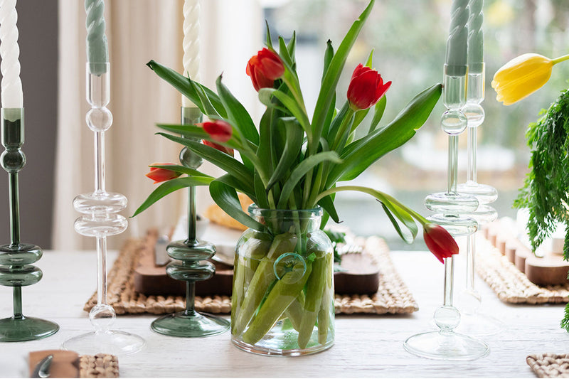 French Bee Mason Jar Small used as a vase, featuring red flowers. The jar's elegant, wide-mouth design with vintage-inspired bee seal adds a timeless touch.