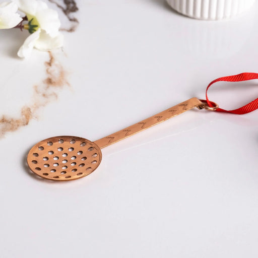 Handmade Copper Miniature Kitchen Utensil Ornament, Skimmer, with perforated bowl, engraved handle, and red ribbon, evoking nostalgic charm from Athens Cooks.