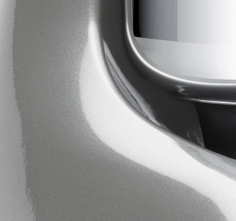 Close-up of the Ankarsrum Stand Mixer, showcasing its sleek metal design near a recessed handle, highlighting its robust, durable craftsmanship for serious home bakers.