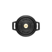 Staub | Mini Round Dutch Oven, Black, 0.275 QT, top-down view with embossed lid and side handles, embodying Staub's renowned craftsmanship for single-serve culinary creations.