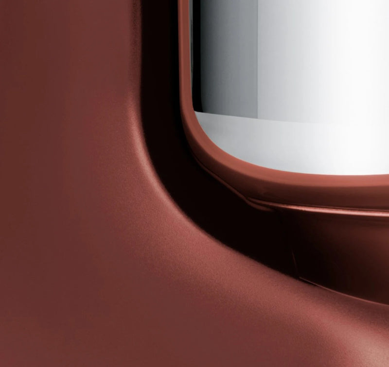 Close-up of Ankarsrum stand mixer's red metal surface, showcasing its sleek design and durable craftsmanship for versatile kneading and mixing in the kitchen.