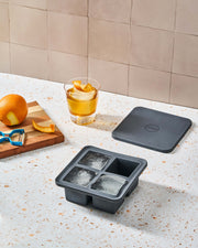 W&P | Peak Reusable Silicone Ice Trays - Charcoal Extra Large, featuring a silicone mold with four deep square wells, ideal for creating slow-melting, large-format ice cubes.