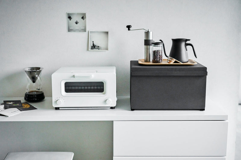 Yamazaki Home | Tower Bread Box, Steel, Black, sits stylishly on a countertop, surrounded by coffee essentials and a toaster, enhancing kitchen organization.