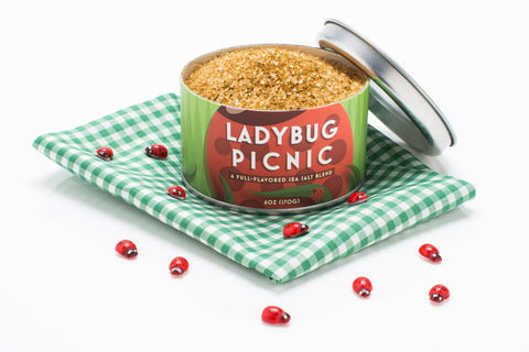 Beautiful Briny Sea | Ladybug Picnic Sea Salt can on checkered cloth, showcasing gourmet salt from Athens Cooks' specialty food collection.