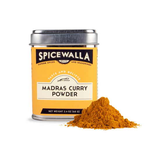 Spicewalla | Madras Curry Powder tin beside a mound of yellow-orange curry powder, highlighting its warm, citrusy, and mild flavor profile.