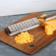 Microplane | Master Series Extra Coarse Grater with Walnut Handle on a cutting board, alongside cheddar blocks and grated cheese, highlighting its elegant design and superior functionality.