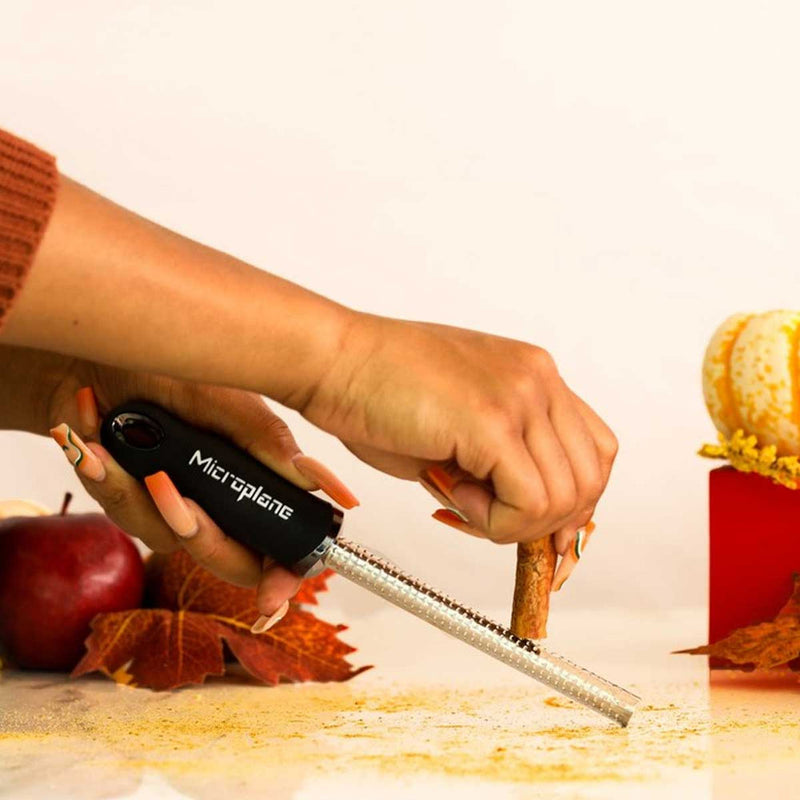 Microplane | Premium Classic Spice Rasp Grater being used to grate cinnamon, showcasing its efficient design and sharp blades, ideal for tough spices like nutmeg.