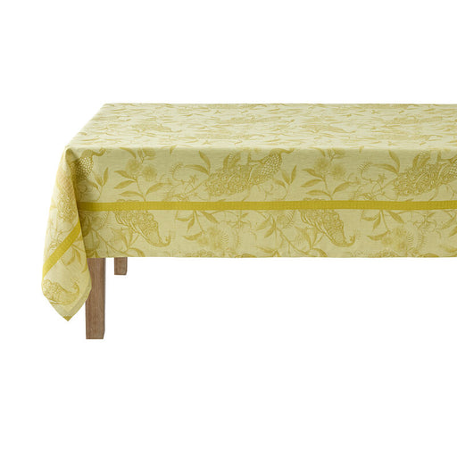 Le Jacquard Francais | A L'Orangerie Tablecloth, Yellow, 69 x 69, featuring peacock motifs and floral vines, elegantly draped on a wooden table.