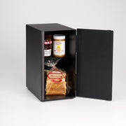 Yamazaki Home | Bread Box, Vertical, Steel, Black, showcasing two jars of spread and a loaf of bread, offering stylish storage for fresh baked goods.